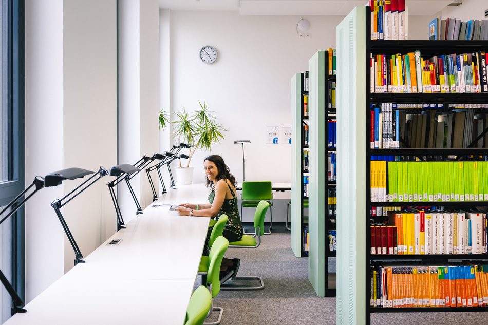 Studentin lernt an einem Arbeitsplatz in der Bibliothek der bbw Hochschule
